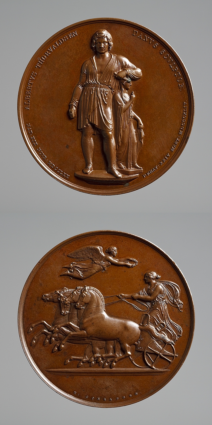 Medalje forside: Bertel Thorvaldsen med Håbets gudinde. Medalje bagside: Victoria nærmer sig en sejrende quadriga 