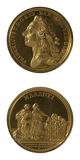 Den Store Guldmedalje forside: Kong Frederik 5. Medaljens bagside: Retfærdigheden vises af Minerva hen til tre genier