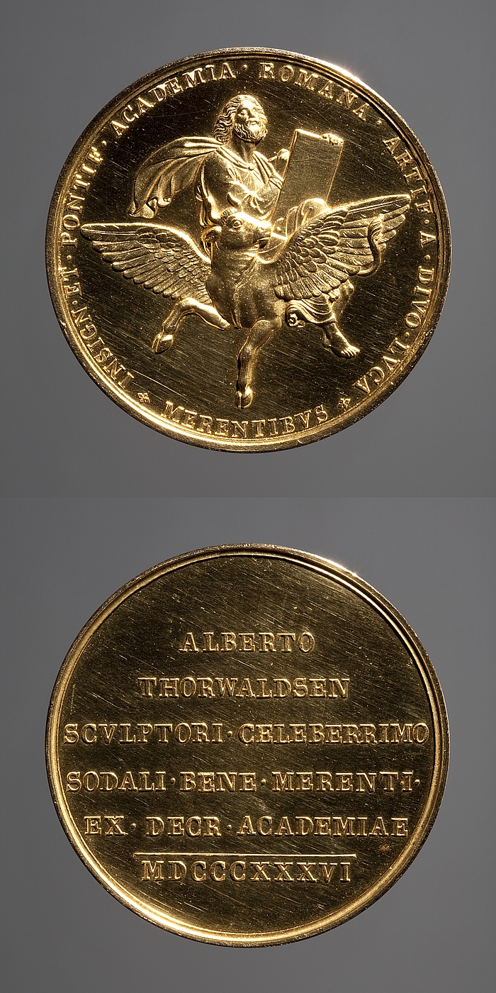 Medaljens forside: Lukas. Medaljens bagside: Indskrift